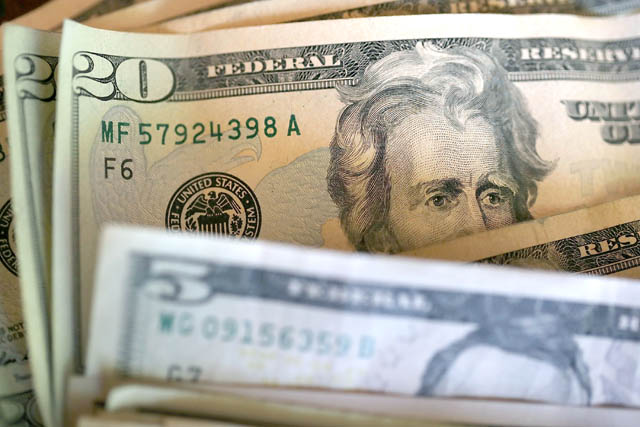 In this photo illustration, twenty and five dollar bills are displayed on Tuesday in San Anselmo, California (AFP photo)